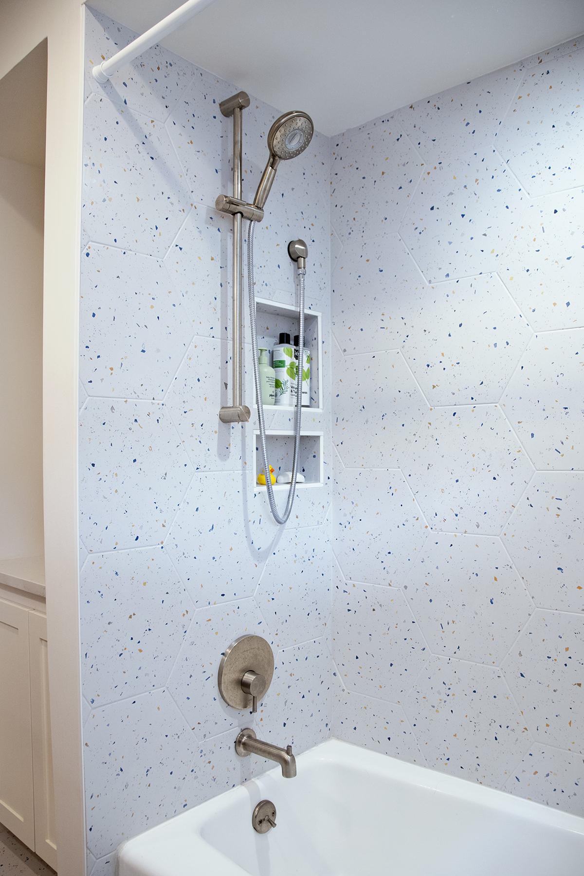 Bathroom with tub and speckled tile